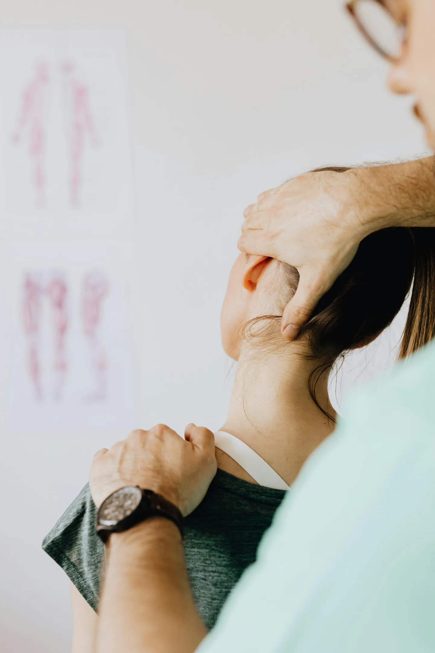 Chiropractor assessing a patient's neck and shoulder